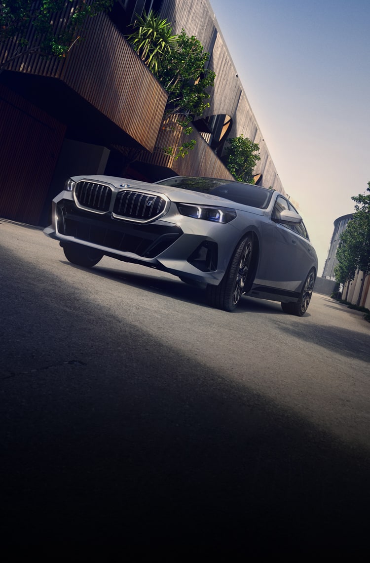 A dramatic shot of the BMW i5 in an urban landscape.