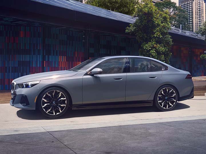 A side view of the BMW i5 Sedan parked on a city street