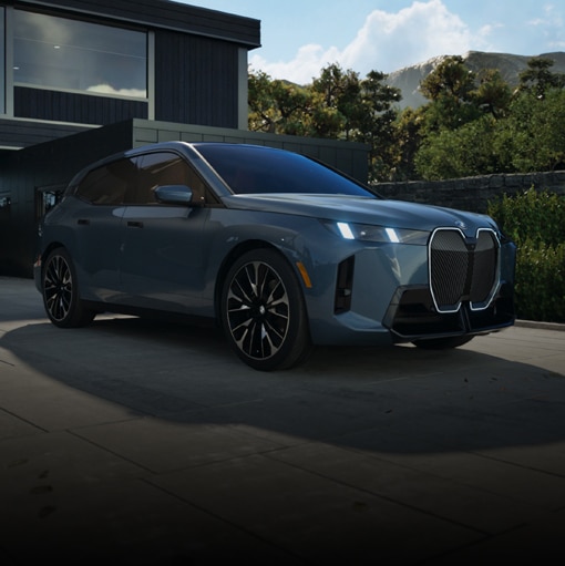 Dramatic low front view of the BMW iX with headlights aglow