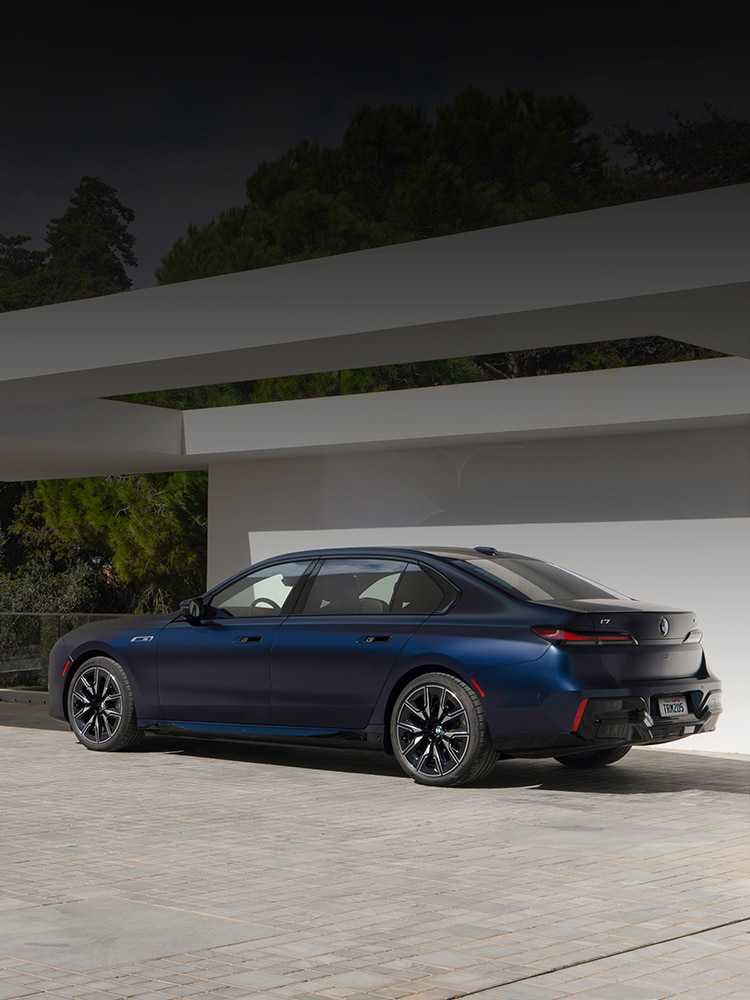 The BMW i7 parked under a modern open air structure