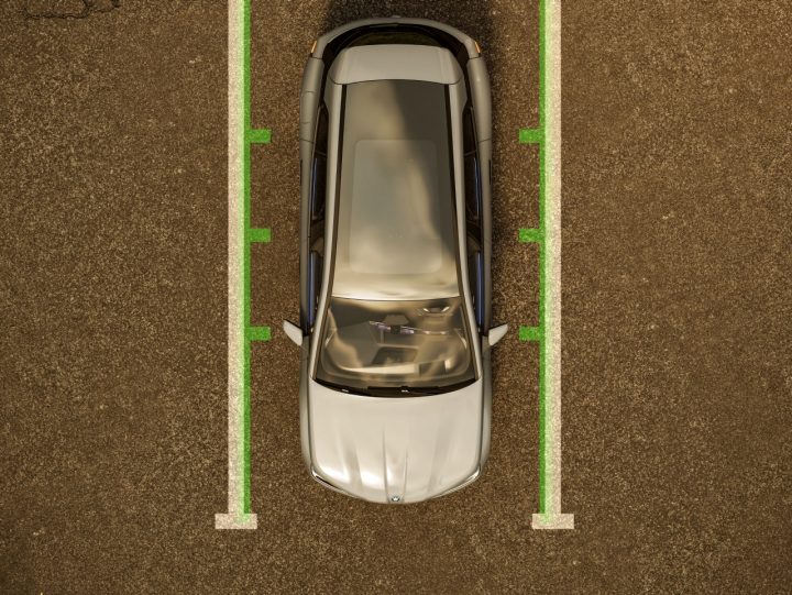 Birds-eye view of a 2025 BMW iX parked between two painted parking lines.