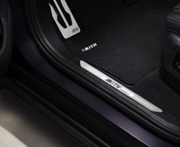 A close up of the driver's velour seat floor mats featuring Kith logo