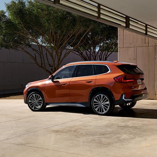 A BMW X1 parked under a modern overhang