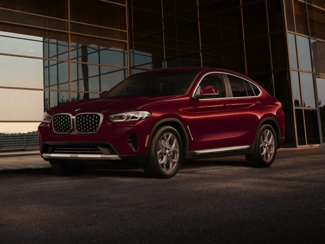 The 2025 BMW X4 xDrive30i in front of a glassy modern building