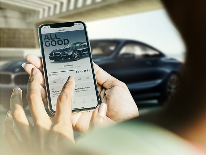 Detail of a woman using her smartphone with My BMW App on the screen