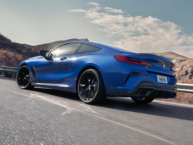 2026 BMW M850i xDrive Coupe driving on an open road, showcasing capability of standard Adaptive M Suspension