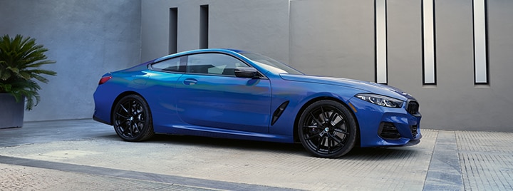 The 2026 BMW M850i xDrive parked in front of a modern urban background