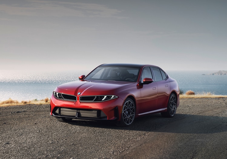 The BMW 3 Series parked in front of a scenic landscape