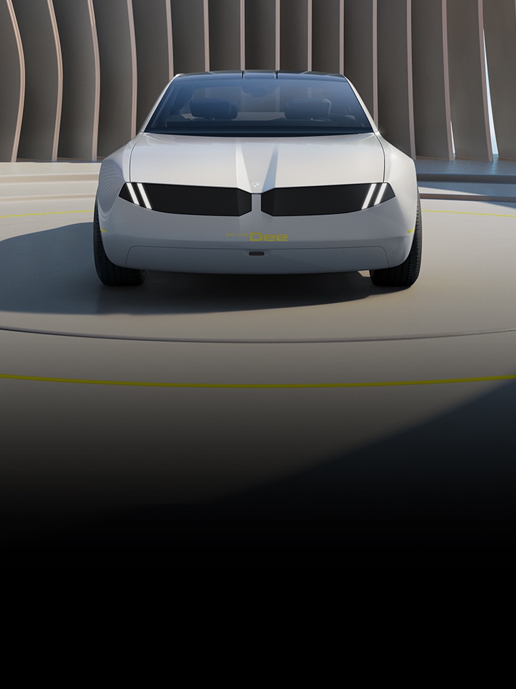 Front view of the BMW i Vision Dee set against a futuristic background and slender columns