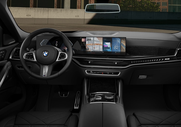 Interior shot of the 2024 BMW X6 featuring the steering wheel and dash